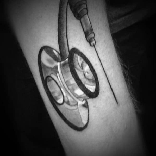 Realistic stethoscope tattoo with a syringe detail on the forearm, symbolizing precision, dedication, and passion for the medical field.