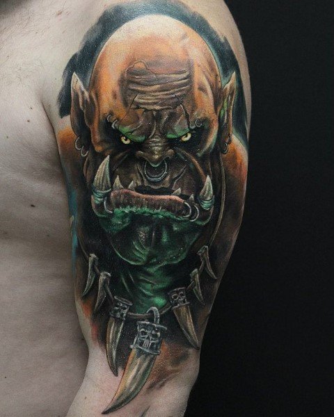 Realistic tattoo of an orc from World of Warcraft, featuring glowing yellow eyes, sharp tusks, and tribal armor, inked on the upper arm.