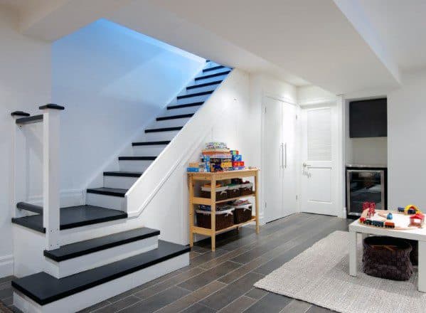Minimalist staircase without railing, leading to a basement playroom with tile flooring and storage.