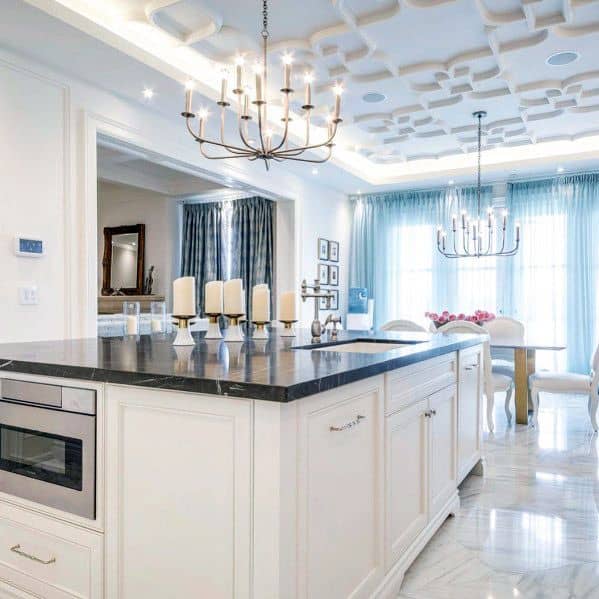 Elegant kitchen with white LED crown molding lighting, beautiful chandelier accents, and marble countertops