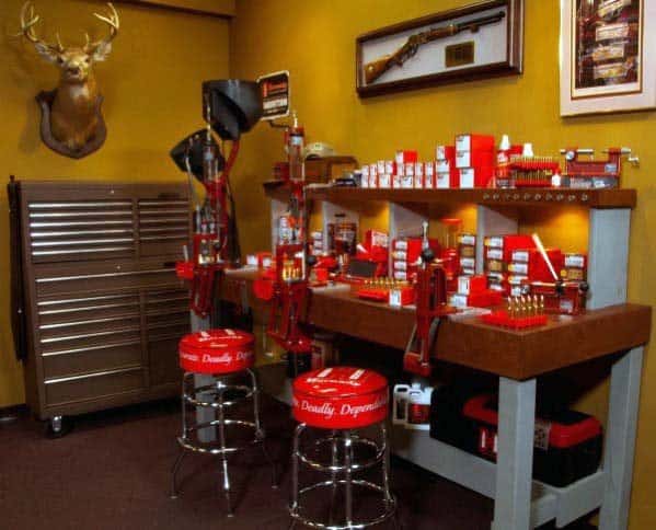 Red-themed reloading bench setup with branded stools, organized tools, and warm lighting for a polished workspace