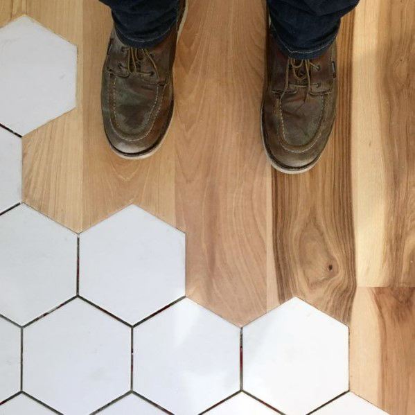 Unique tile-to-wood floor transition with white hexagonal tiles blending into warm wood planks for a seamless, artistic design