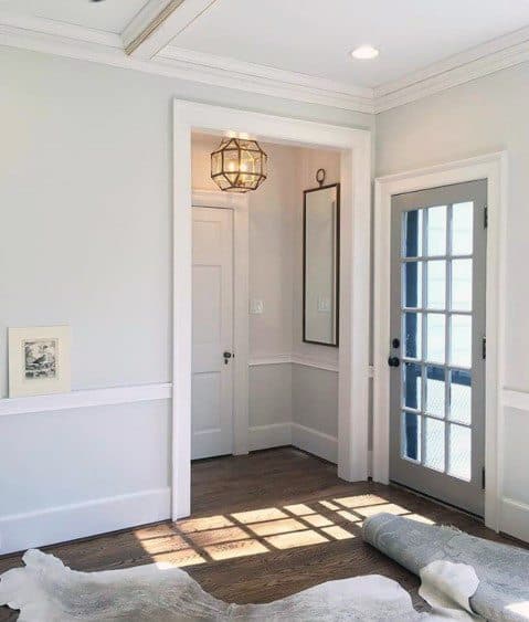 Bright room with white chair rail molding, French doors, and a geometric pendant light for a stylish and airy look