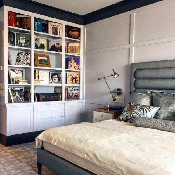Bedroom with a plush bed and a curated bookshelf displaying albums and books