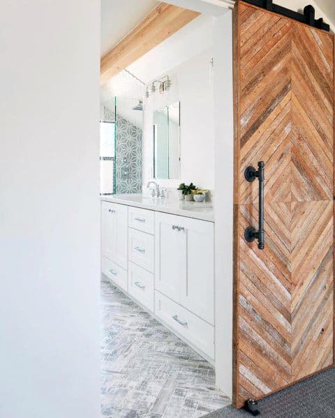 White bathroom with cabinets and a rustic wooden sliding barn door