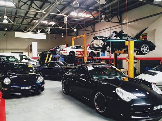 A spacious, workshop-style garage with high ceilings, multiple car lifts, and ample lighting for vehicle maintenance and storage.