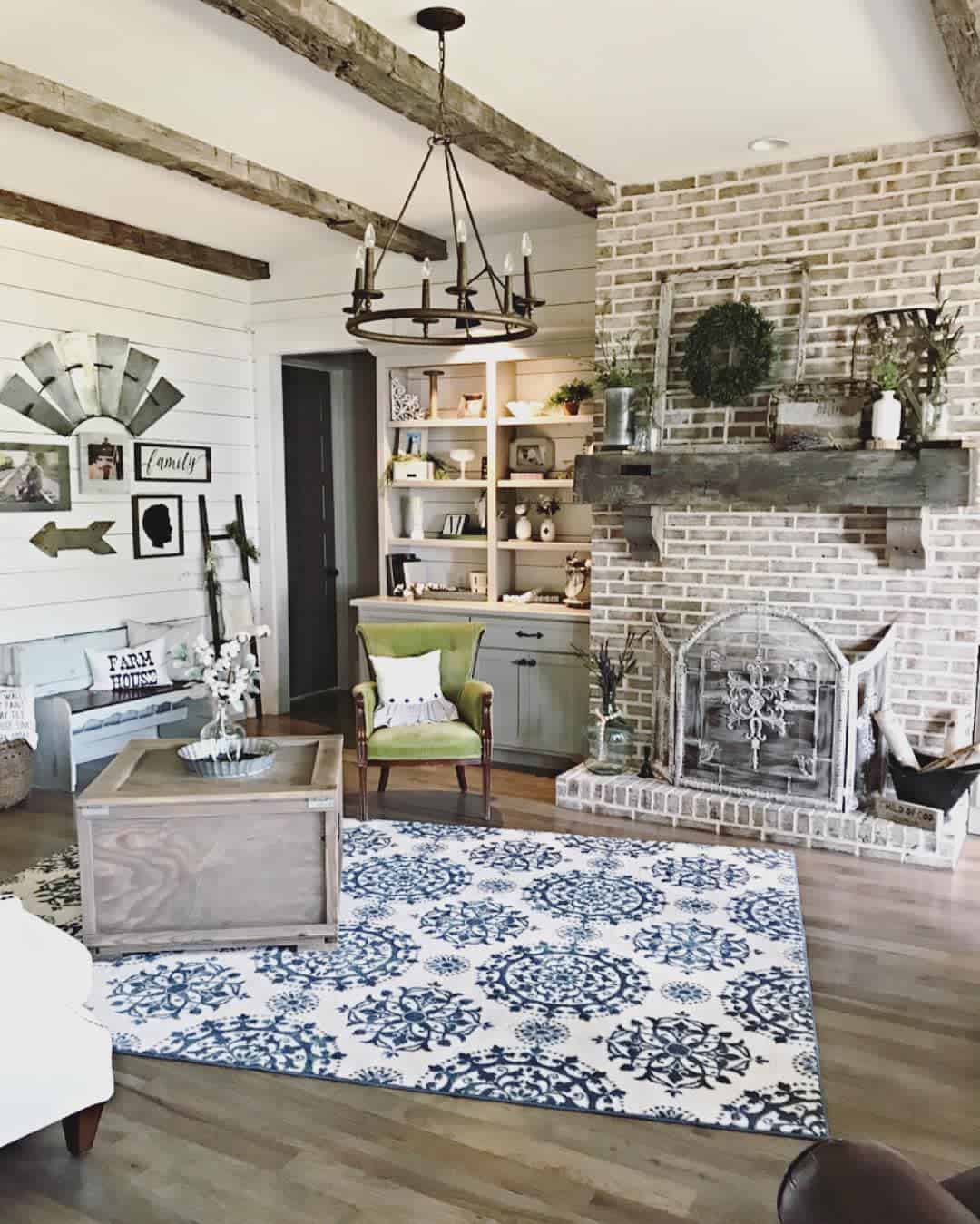 exposed beams brick fireplace shiplap walls rustic living room chandelier