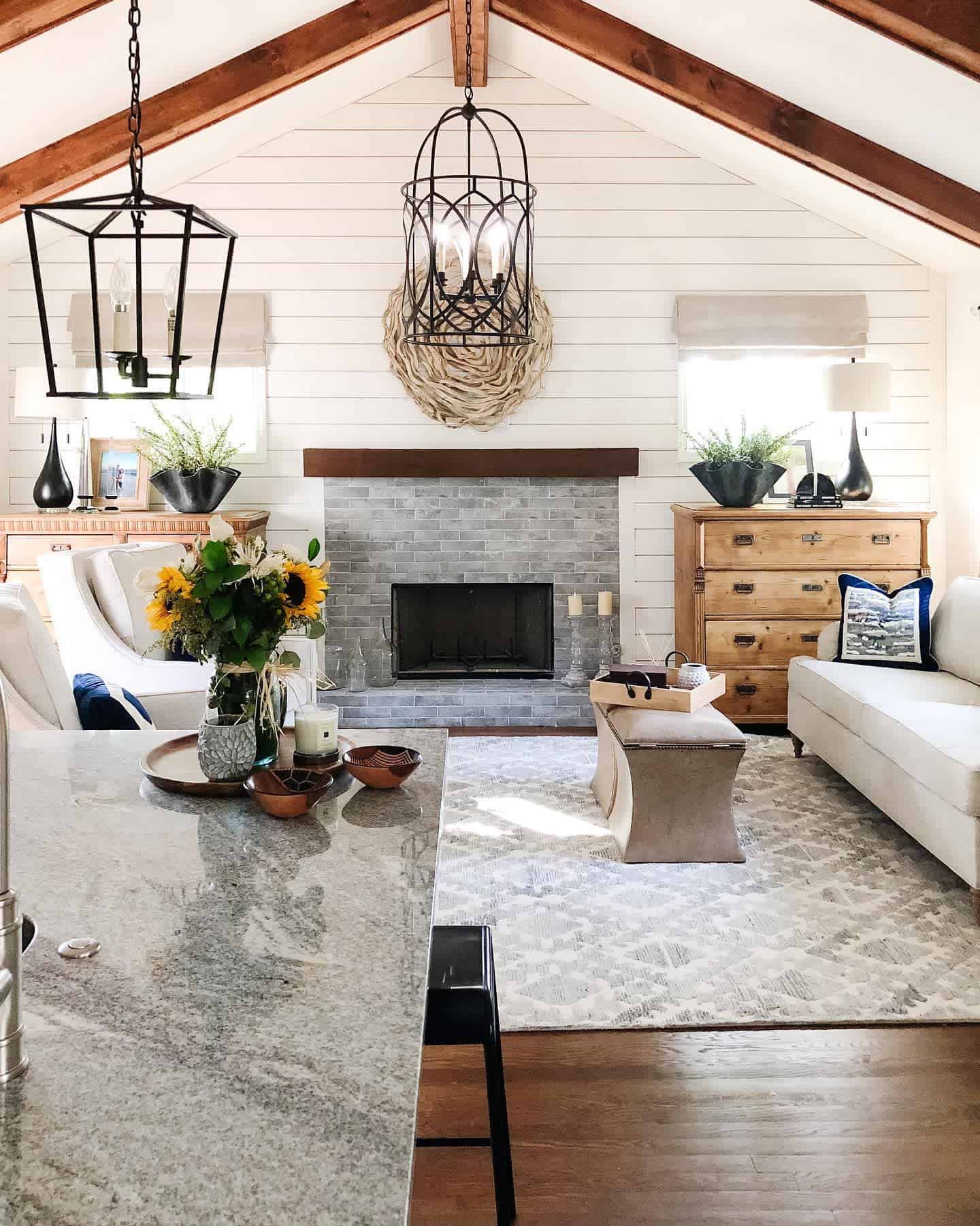 shiplap wall gray stone fireplace white sofa wood cabinet exposed wood beams