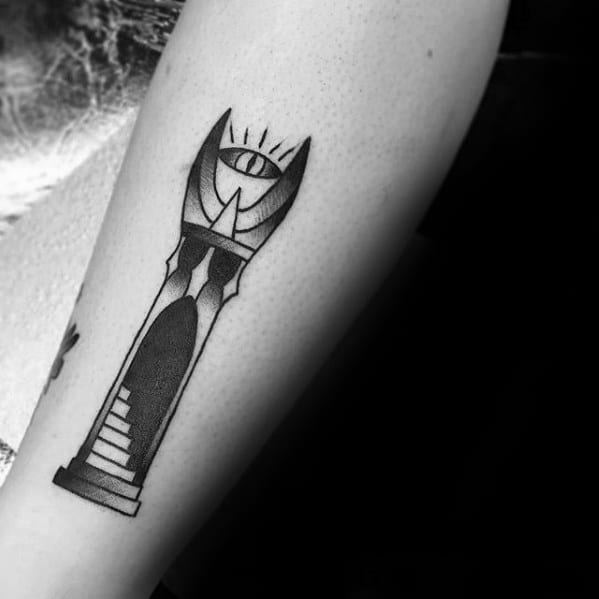 A black and white tattoo of an abstract tower with an Eye of Sauron motif elegantly wraps around the arm