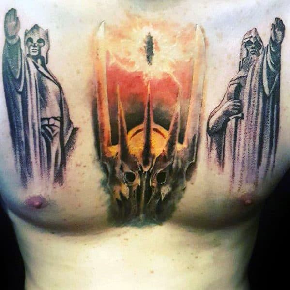 Tattoo of two figures and a helmet, with the Eye of Sauron blazing amidst a fiery eye and dramatic landscape, on a person's chest