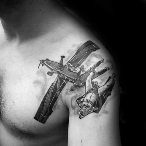 Realistic tattoo of a man falling from a crashing plane, inked across the chest and shoulder with dramatic motion and shading.