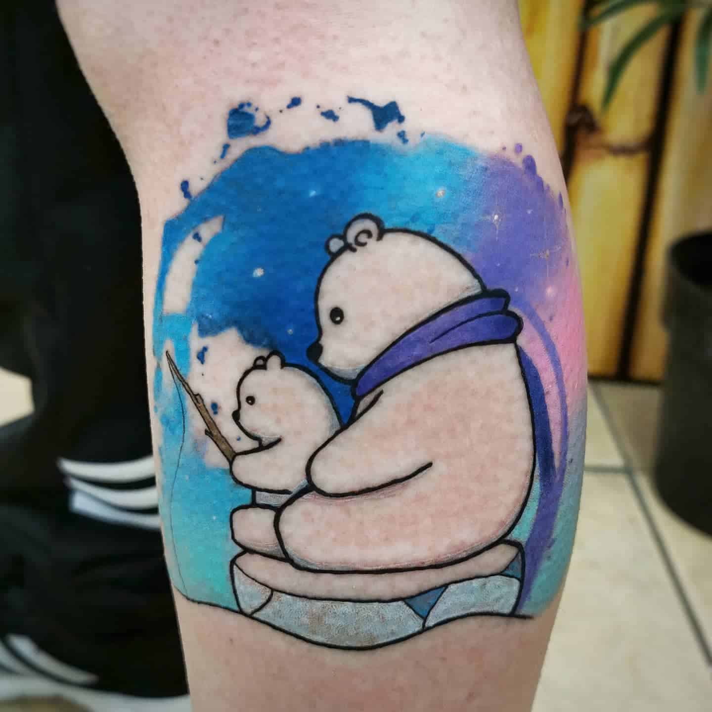 Tattoo of two polar bears with a fishing rod, sitting on ice, against a watercolor-style blue and purple background