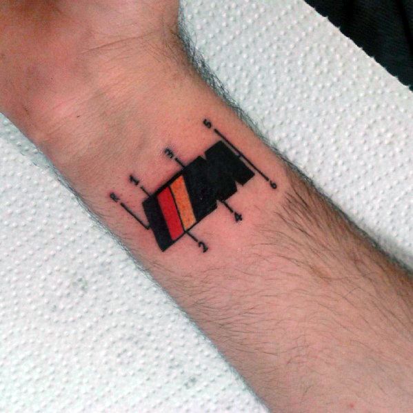 Minimalist BMW M gear shift tattoo on wrist, featuring bold M stripes and a manual transmission pattern for a sleek automotive design.