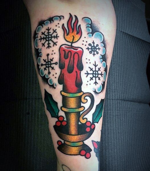 Traditional Christmas tattoo of a dripping red candle in a brass holder, surrounded by holly leaves, berries, and snowflakes for a festive vintage look.
