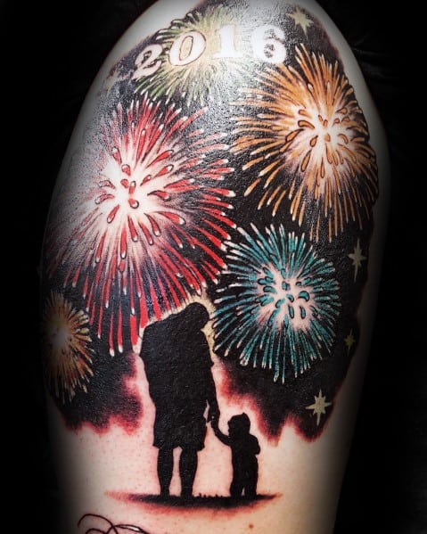 Tattoo of a parent and child silhouette watching fireworks, with "2016" above, creating a sentimental and vibrant night-time scene.