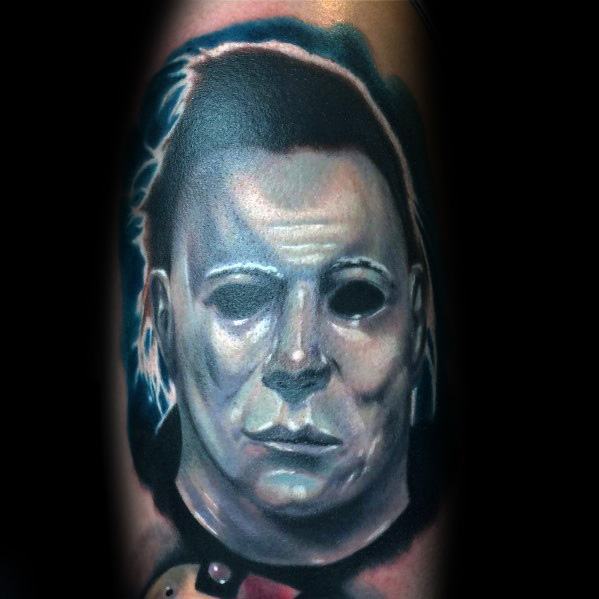 Bold and detailed Michael Myers tattoo with eerie lighting, capturing his haunting mask and sinister presence in a realistic style.