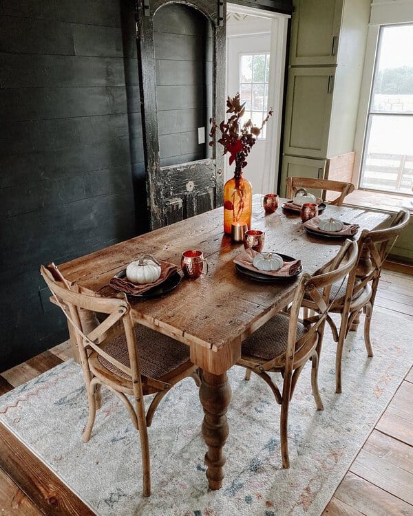 Boho dining room with farmhouse style, rustic wooden table, and cozy fall decor.