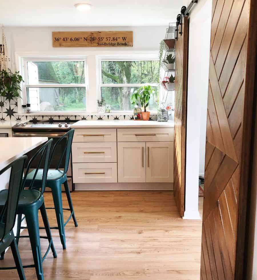 farmhouse kitchen sliding barn door white cabinets green chairs
