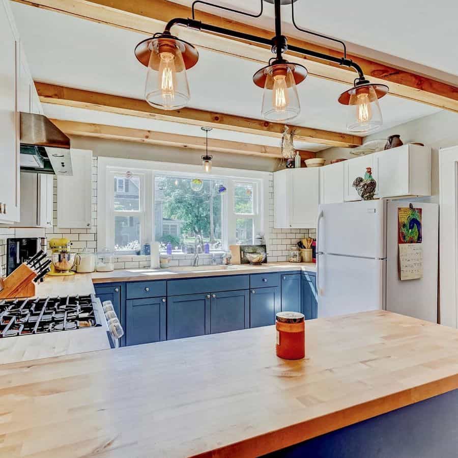 farmhouse kitchen blue cabinets wood countertop white tile backsplash