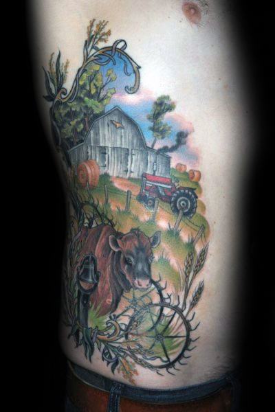 Colorful side tattoo of a peaceful farm scene with a cow, red tractor, barn, hay bales, corn, and barbed wire accents.