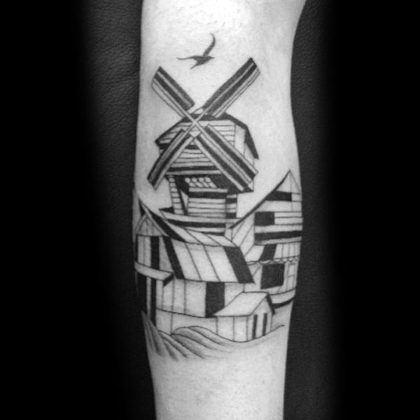 Geometric blackwork tattoo of a windmill above abstract farm buildings, with bold lines and a bird flying overhead.