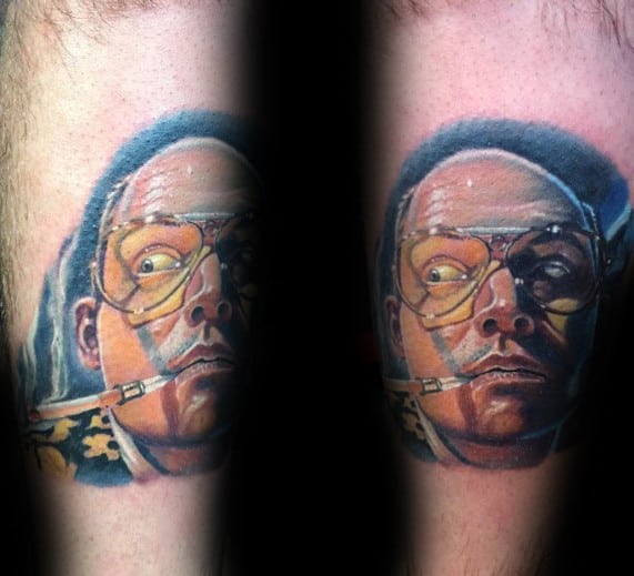 Realistic Hunter S. Thompson tattoo featuring his intense gaze, aviator glasses with a yellow tint, and a cigarette, with bold shading and color.
