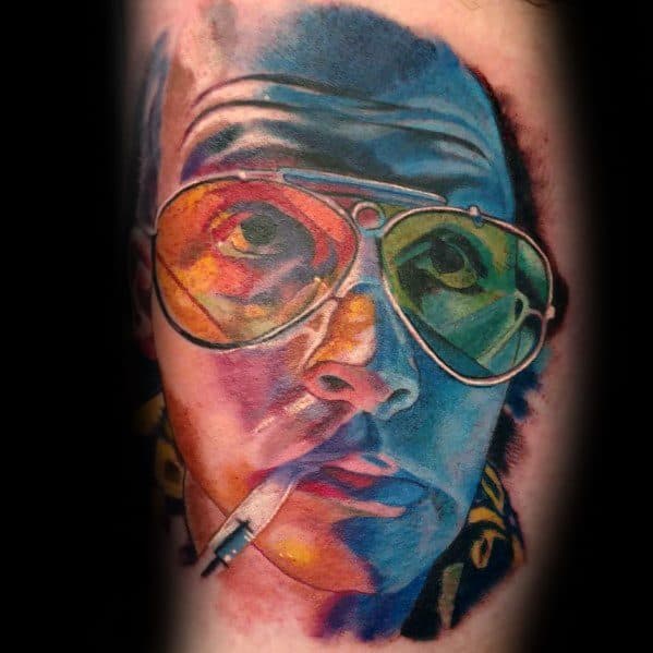 Vibrant Hunter S. Thompson tattoo featuring multicolored aviator glasses, bold shading, and a cigarette, creating a psychedelic effect.