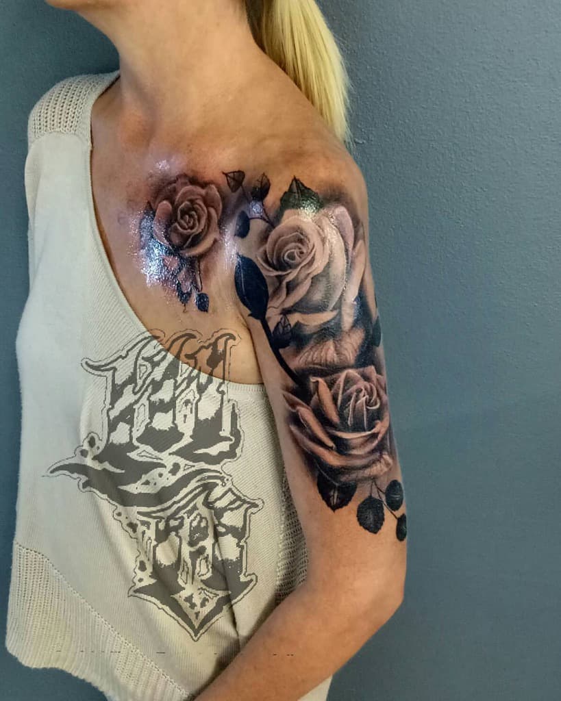 A woman with a rose tattoo that extends into an elegant sleeve on her shoulder and upper arm