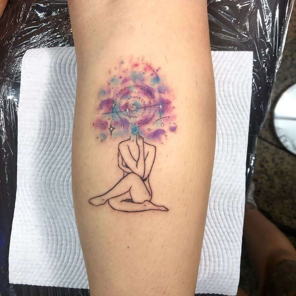 Minimalist tattoo of a seated figure with hands over their face, merging into a cosmic galaxy of stars and swirls in watercolor shades of blue, pink, and purple