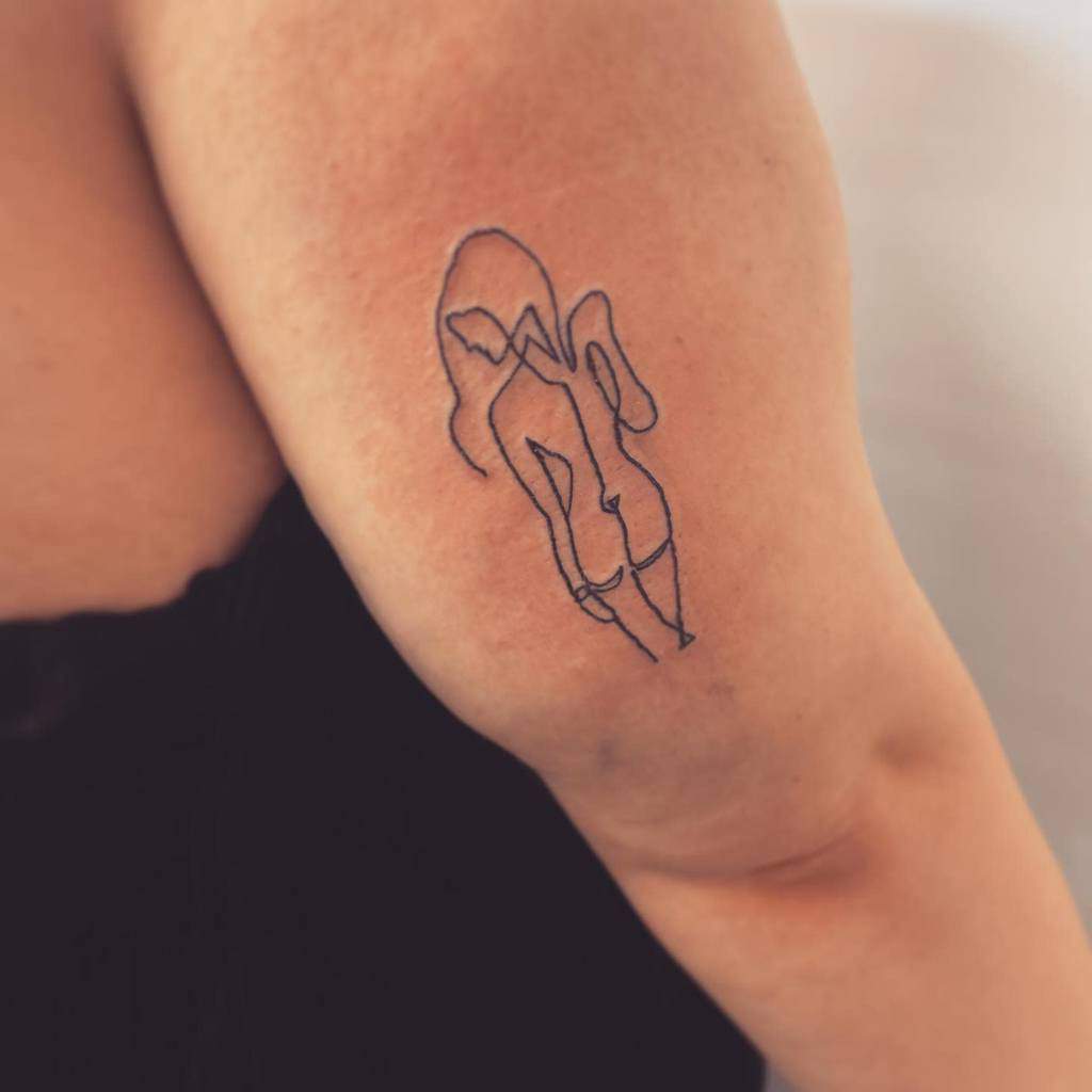 Minimalist single-line tattoo of a woman's silhouette with abstract flowing lines