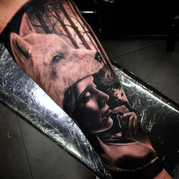 Tattoo of a woman smoking with a wolf above her head, set against a forest background