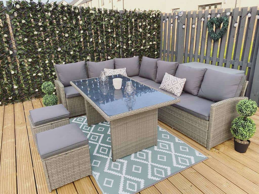 backyard deck wicker furniture gray fence trellis white roses
