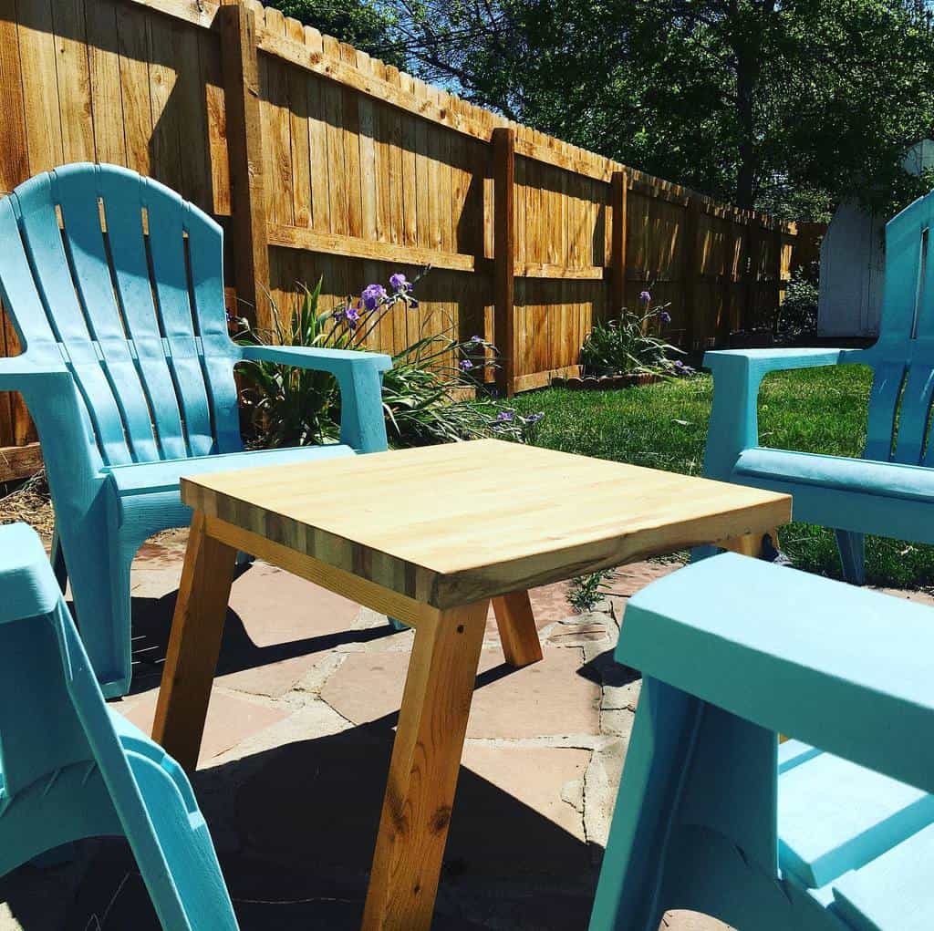 small patio with blue plastic chairs and wood table