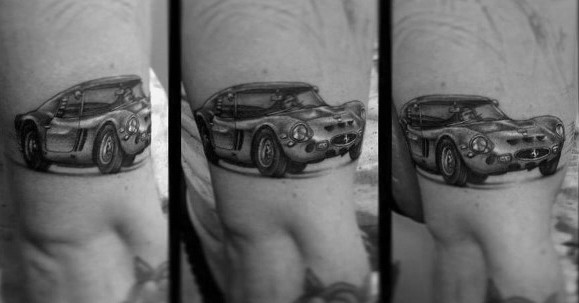Realistic Ferrari car tattoo wrapping around man's arm, highlighting detailed design and classic automotive elegance.