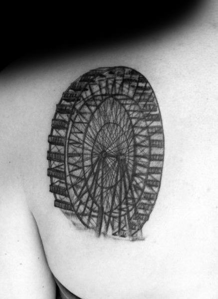 Detailed black ink Ferris wheel tattoo on the upper back, featuring intricate line work and a realistic perspective for a bold, striking design.