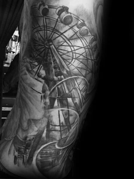 Realistic black and grey Ferris wheel tattoo with intricate shading, featuring a dramatic perspective and a roller coaster for an immersive amusement park theme.