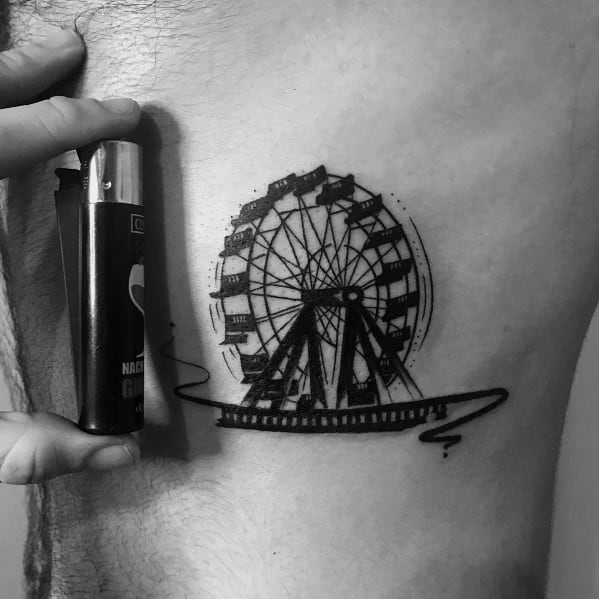 Small black ink Ferris wheel tattoo with bold shading and fine details, featuring a flowing line beneath for an artistic and dynamic touch.
