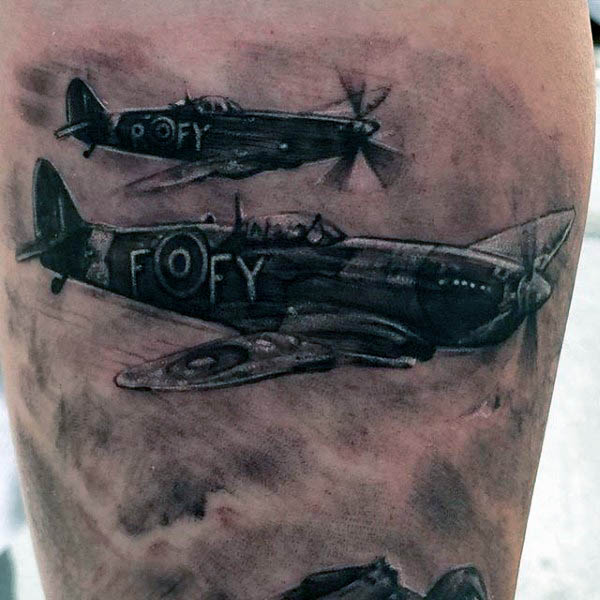 Tattoo of two vintage airplanes in flight on a person’s arm