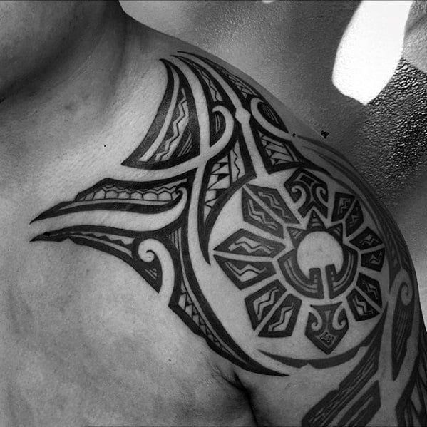 Filipino sun tattoo on the shoulder with sharp tribal extensions, bold rays, and intricate blackwork inspired by traditional ethnic patterns.