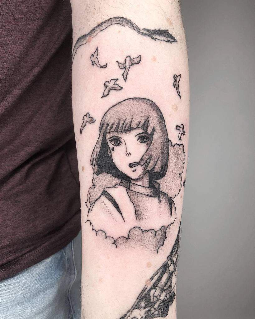 Black and grey tattoo of Haku from Spirited Away, surrounded by clouds and flying birds, with a serpent-like dragon form above