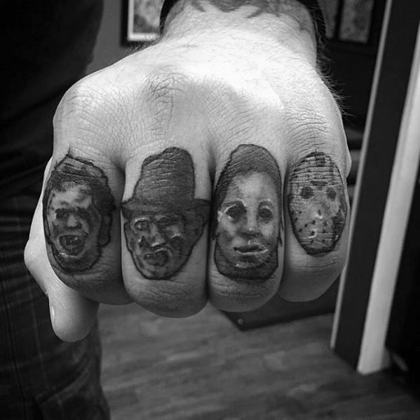 Black and grey knuckle tattoos featuring horror icons: Leatherface, Freddy Krueger, Michael Myers, and Jason Voorhees for a chilling design.
