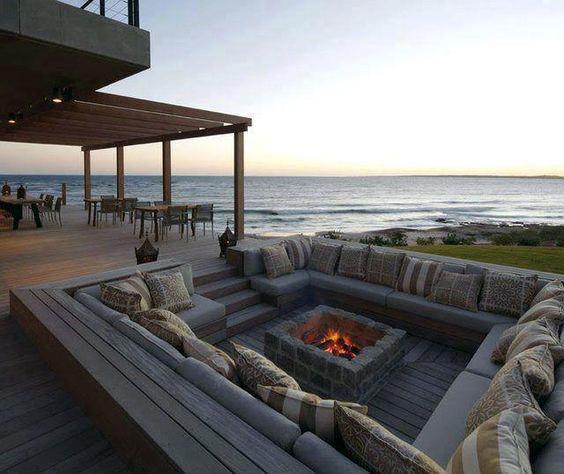 Cozy outdoor patio seating by a fire pit, perfectly set to overlook the ocean at sunset