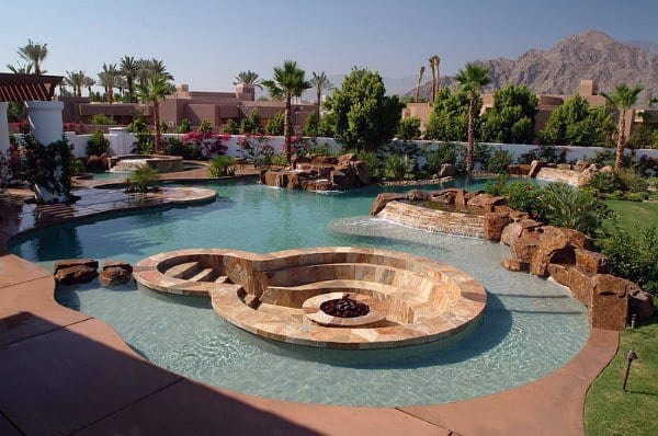 Luxury backyard pool with stone hot tub, fire pit, palm trees, and mountain view