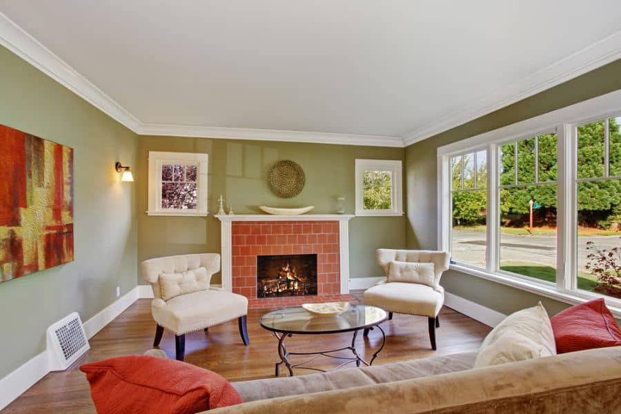 green wall living room brick fireplace glass table white chairs sofa 