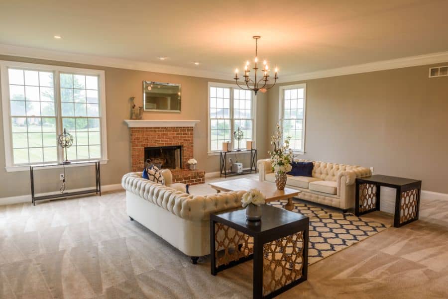elegant family room carpet white sofas wood table brick fireplace chandelier