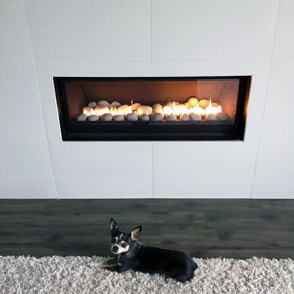 Modern gas fireplace with a sleek black frame and white stone accents inside.