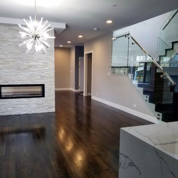 Linear gas fireplace with a black frame set in a stacked stone wall.