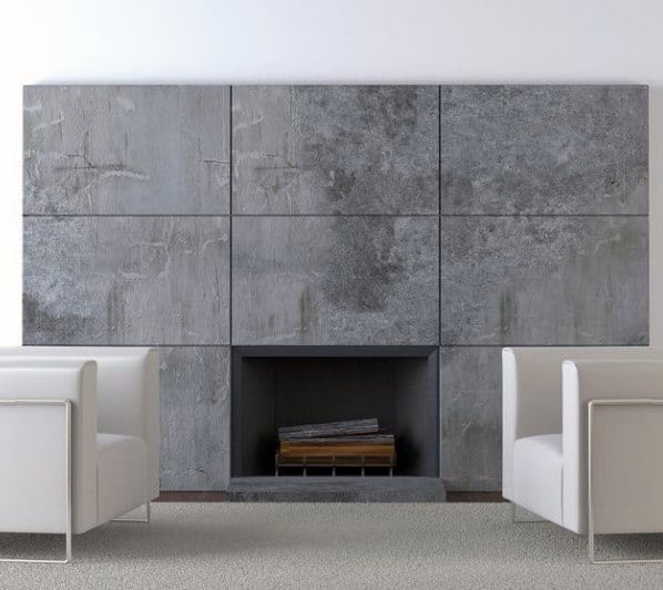 Modern fireplace with textured concrete wall panels and minimalist white armchairs.