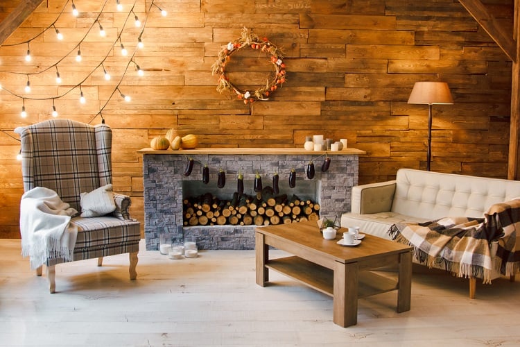 wood shiplap living room with pattern accent chair and hanging lights