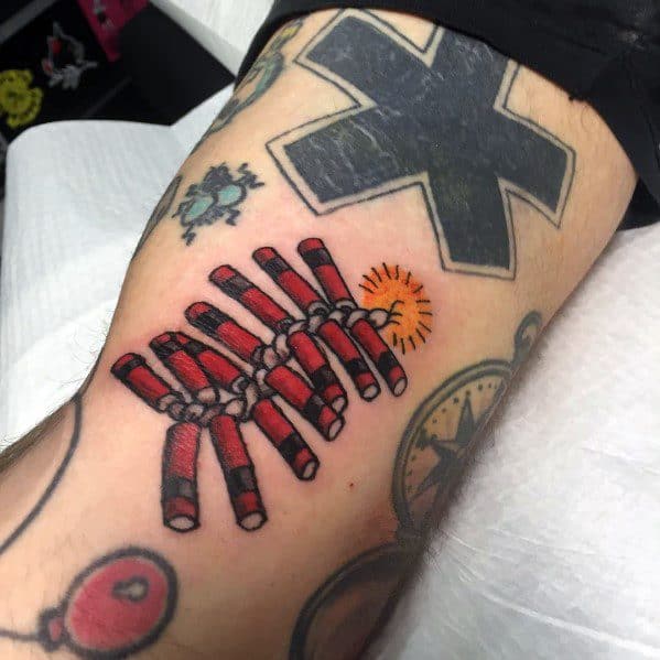 Tattoo of a bundle of red firecrackers tied together, with a lit fuse sparking, designed in a bold traditional style with vibrant details.